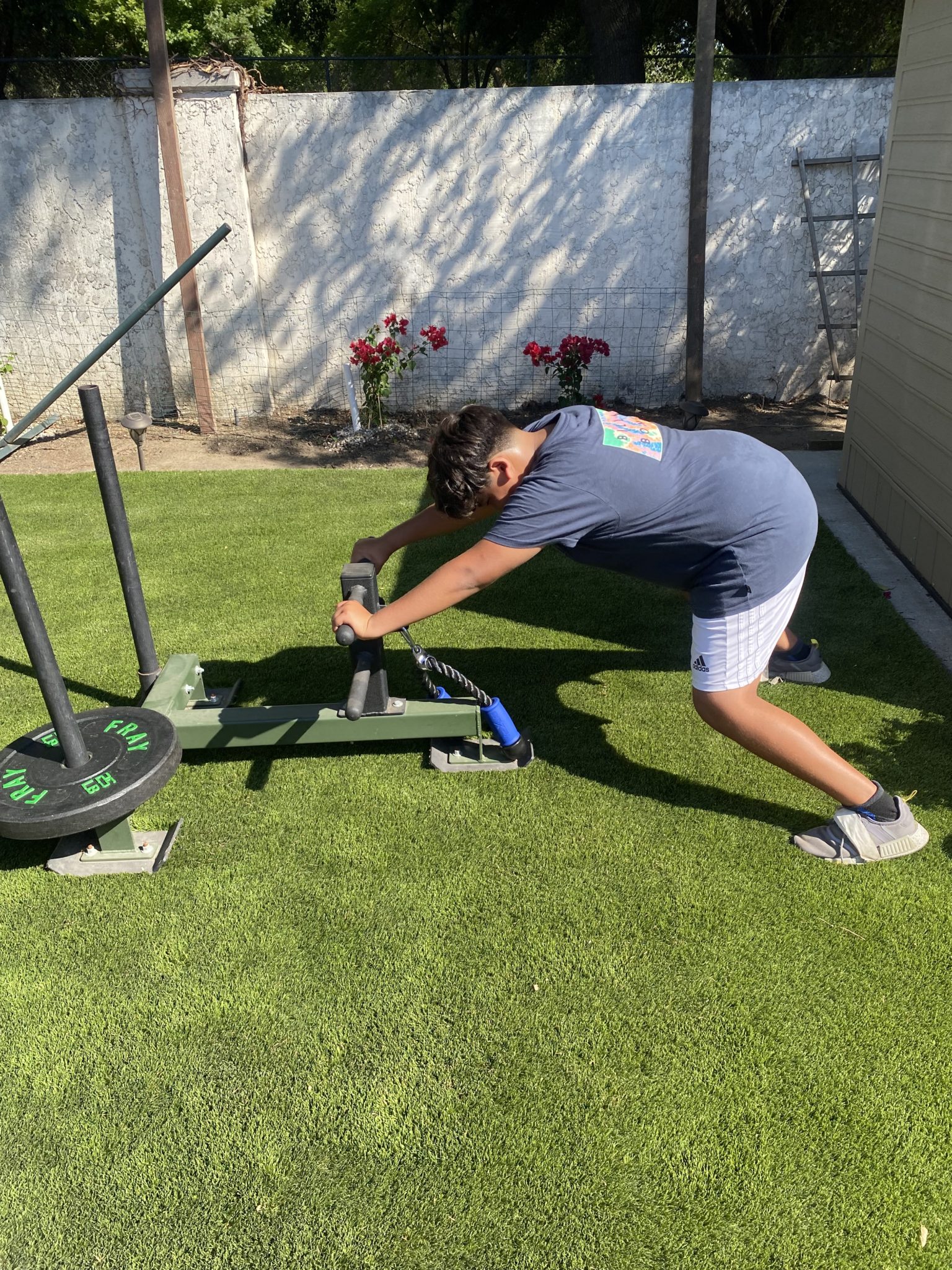 An athlete driving a weighted sled across the turf
