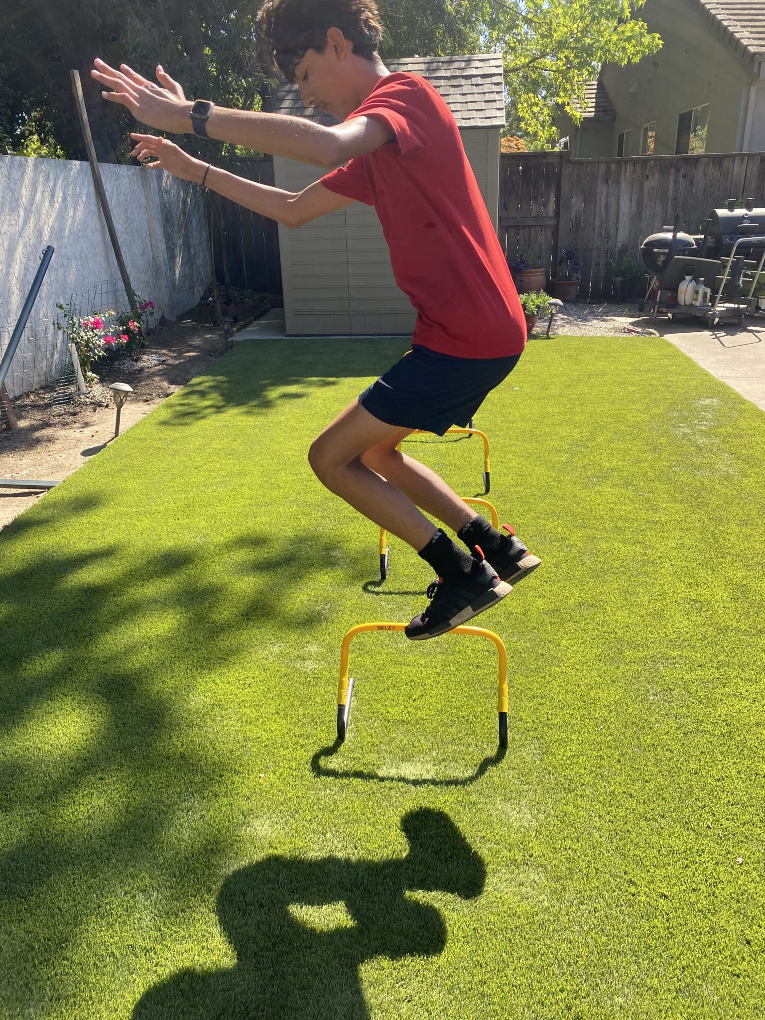 An athlete clearing a mini hurdle during plyometric training