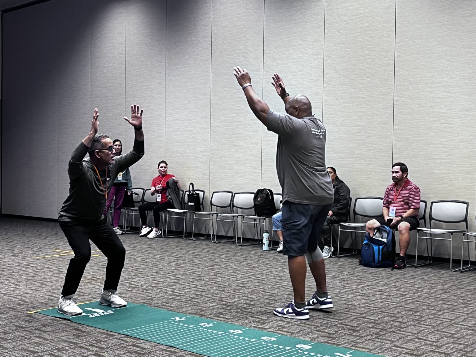 Shawn Jenkins leading a broad-jump drill at a coaching clinic